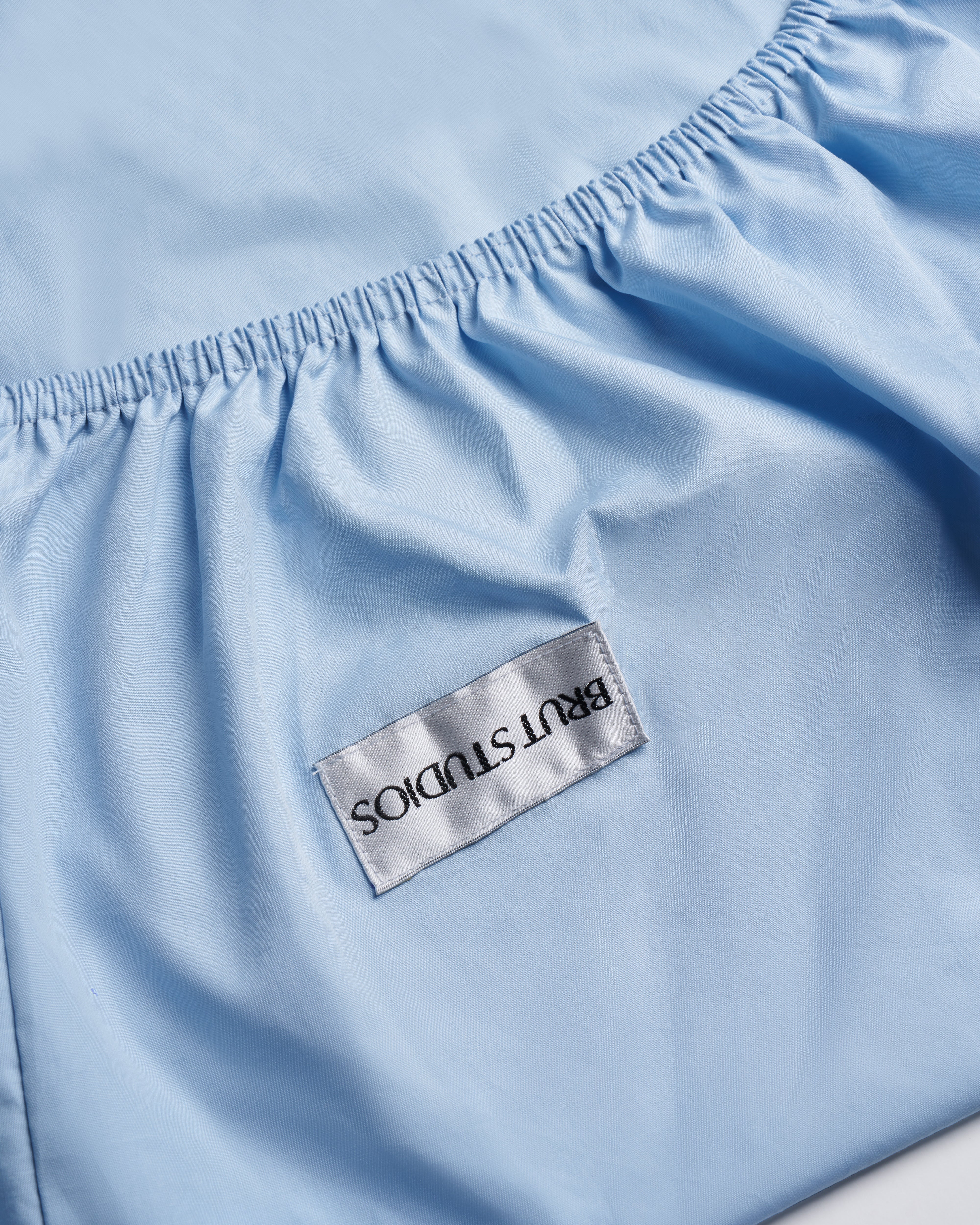 Concrete Blue percale fitted sheet, styled on bed